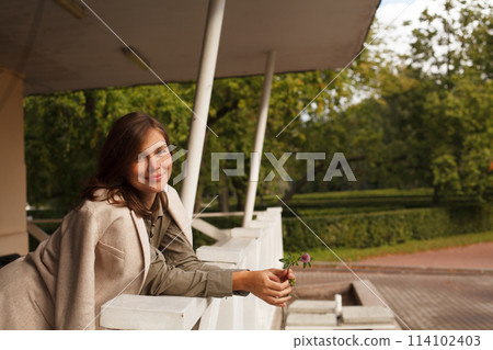 Attractive woman with brown hair and make-up resting outdoor Attractive woman with brown hair and make-up resting outdoor 114102403