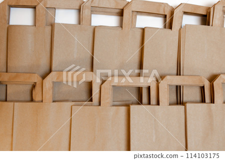 DISPOSABLE BAG OF KRAFT PAPER ON A WOODEN TABLE. RECYCLED SHOPPING PAPER BAG. DISPOSABLE BAG OF KRAFT PAPER ON A WOODEN TABLE. RECYCLED SHOPPING PAPER BAG. 114103175