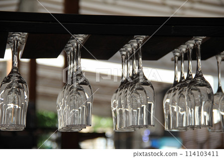 Empty brandy glasses hanging on the wood cup holder 114103411