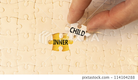 Inner child symbol. Concept words Inner child on beautiful white paper puzzle. Beautiful yellow background. Psychologist hand. Psychological, motivational inner child concept. Copy space. 114104288