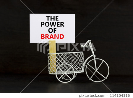 The power of brand symbol. Concept words The power of brand on beautiful white paper on clothespin. Bicycle model. Beautiful black background. Business the power of brand concept. Copy space. The power of brand symbol. Concept words The power of brand on beautiful white paper on clothespin. Bicycle model. Beautiful black background. Business the power of brand concept. Copy space. 114104316