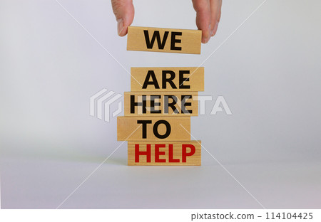 Wooden blocks with text 'we are here to help'. Male hand. Beautiful white background, copy space. Business concept. Wooden blocks with text 'we are here to help'. Male hand. Beautiful white background, copy space. Business concept. 114104425