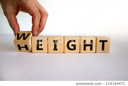 Male hand flips a wooden cube and changes the inscription 'height' to 'weight'. Beautiful white background, copy space. Business concept. 114104471