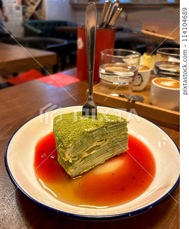 a piece of matcha cake with cranberry sauce 114104689