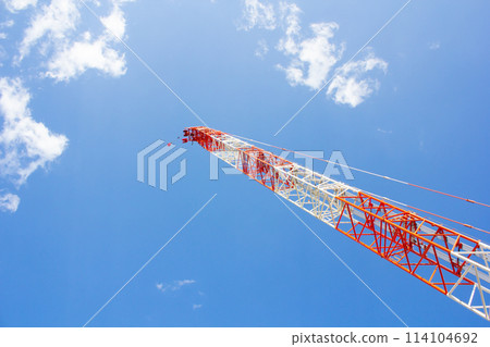 A crane extending into the blue sky 114104692