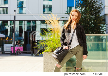 Casual girl with handbag on city street 114105010
