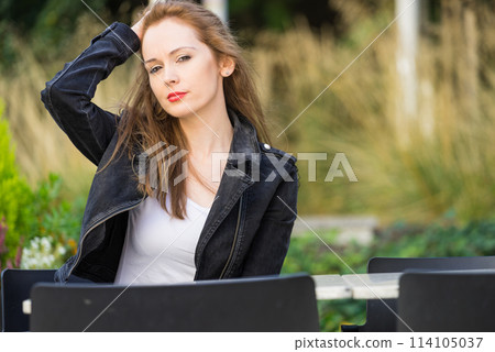 Woman waiting in outdoor restaurant cafe. 114105037
