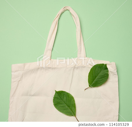 Empty beige textile bag on green background, rejection of plastic bags, flat lay Empty beige textile bag on green background, rejection of plastic bags, flat lay 114105329