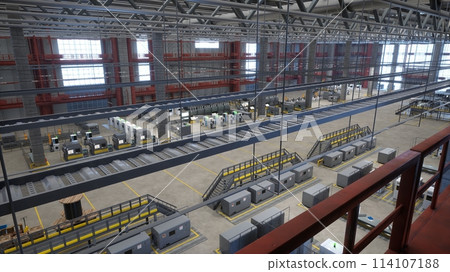 Top down view of industrial facility showcasing rows of high tech machines with control panels and safety signs, 3D render. Manufacturing equipment in automated warehouse, aerial drone shot Top down view of industrial facility showcasing rows of high tech machines with control panels and safety signs, 3D render. Manufacturing equipment in automated warehouse, aerial drone shot 114107188