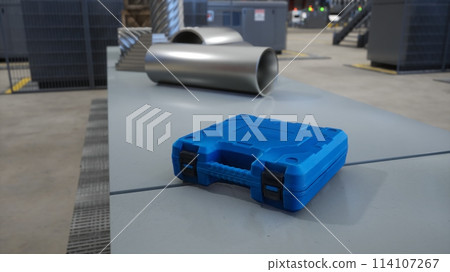 Focus on toolbox in blurry background facility used for energy efficient warehousing handling distribution and storage needs of businesses, 3D render. Close up of toolkit on workbench in logistics hub 114107267