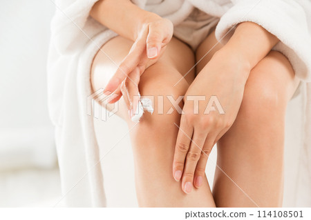 那個女人正在給她的膝蓋塗奶油。 那個女人正在給她的膝蓋塗奶油。 114108501