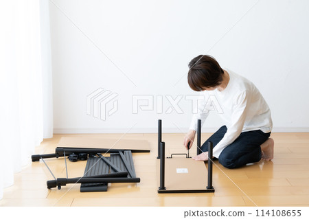 A woman assembles and disassembles a wheeled wagon 114108655