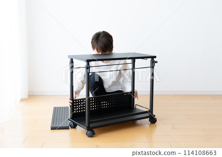 A woman assembles and disassembles a wheeled wagon 114108663