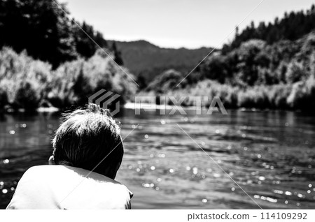 Selective focus on a child rafting down the wild and scenic Rogue River while wearing a life jacket 114109292