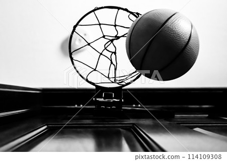 Selective focus on the netting of a miniature toy basketball hoop on the door of a bedroom.  114109308