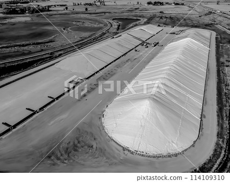 Drone view over grain storage piles being filled and covered Drone view over grain storage piles being filled and covered 114109310