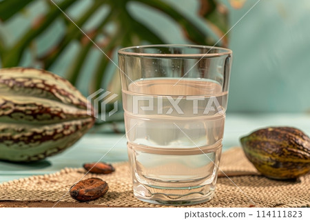 Fresh cacao water in glass and raw cacao pod with white cocoa seed 114111823