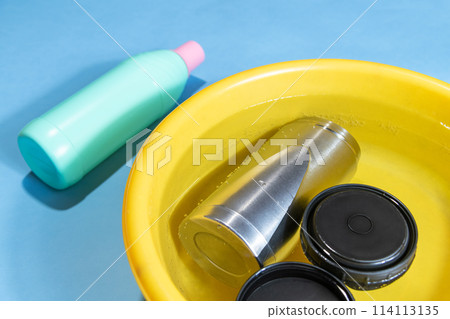 在漂白和消毒過程中將水瓶浸入廚房漂白劑中。 114113135