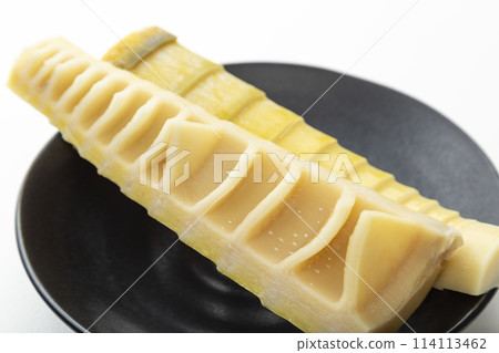 Bamboo shoots on a black plate on a white background Bamboo shoots on a black plate on a white background 114113462