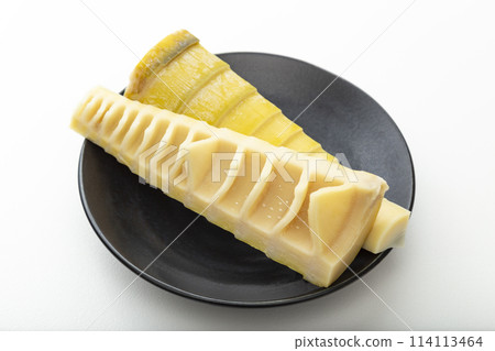Bamboo shoots on a black plate on a white background Bamboo shoots on a black plate on a white background 114113464
