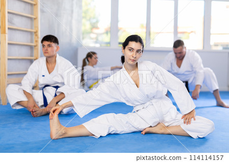 Group of people doing stretching in studio 114114157