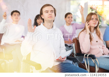 Young male student listening attentively to lecture in lecture hall Young male student listening attentively to lecture in lecture hall 114114353