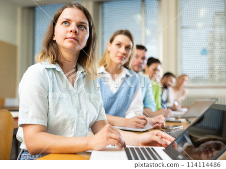 Woman university student writing in classroom 114114486