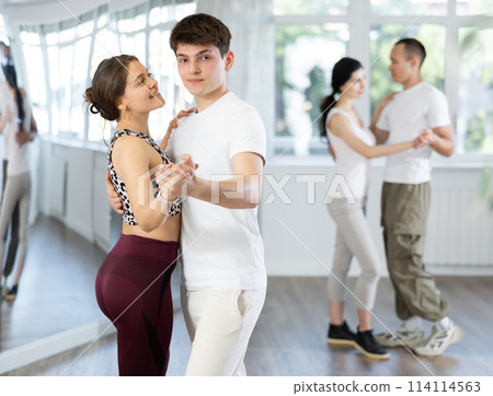 Young guy and girl dancing slow ballroom dance in studio Young guy and girl dancing slow ballroom dance in studio 114114563