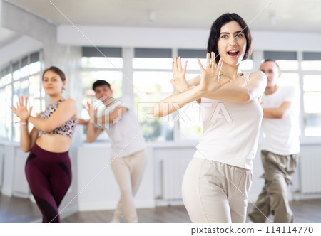 Girl with team of young like-minded people learn to dance modern dances 114114770