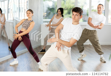 Guy with team of young like-minded people learn to dance modern dances 114114782