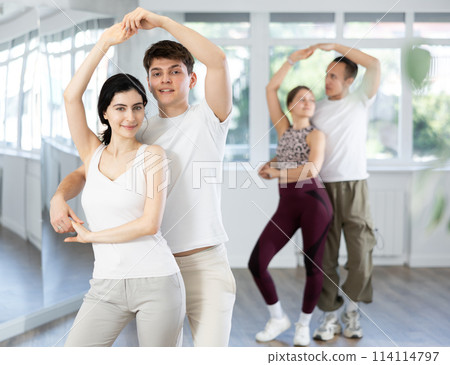 Girl paired up with young man, they train to perform disco fox dance, rehearse performance. 114114797