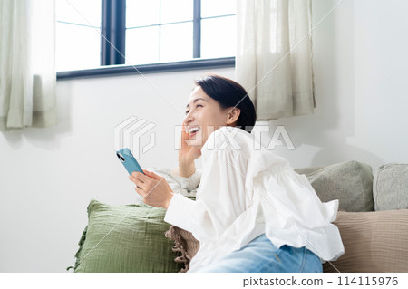 拿著智慧型手機的微笑的女人 114115976