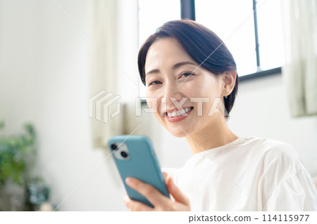 拿著智慧型手機的微笑的女人 114115977