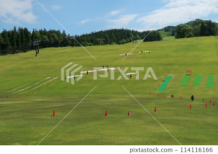 人們在夏季滑雪勝地的斜坡上滑翔傘 114116166