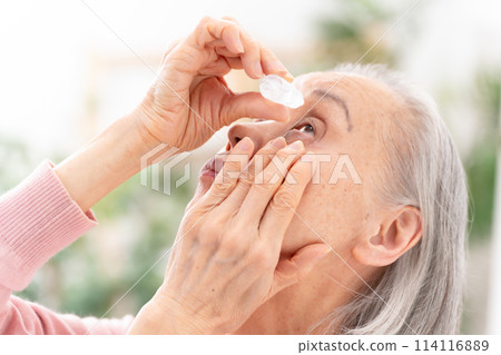 Senior woman pointing eye drops Senior woman pointing eye drops 114116889