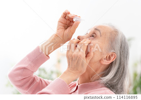 Senior woman pointing eye drops Senior woman pointing eye drops 114116895