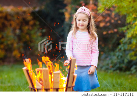 Child with smores at fire. Kids roast marshmallow. 114117111