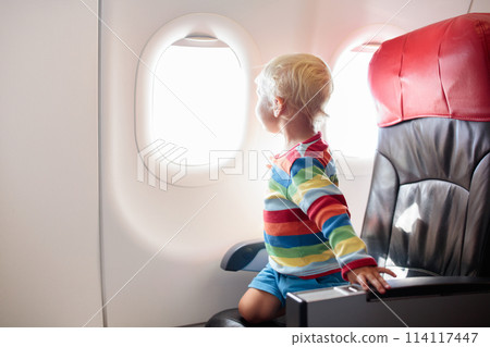 Child flying in airplane. Flight with kids. 114117447