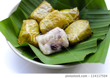 Bundled boiled sticky rice with banana and black beans wrapped in banana leaves Bundled boiled sticky rice with banana and black beans wrapped in banana leaves 114117504