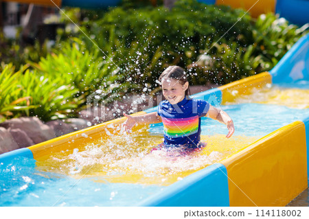 Kids on water slide in aqua park. Summer vacation 114118002