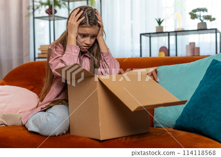 Angry dissatisfied shopper girl unpacking parcel feeling upset mistake delivery broken purchase gift 114118568