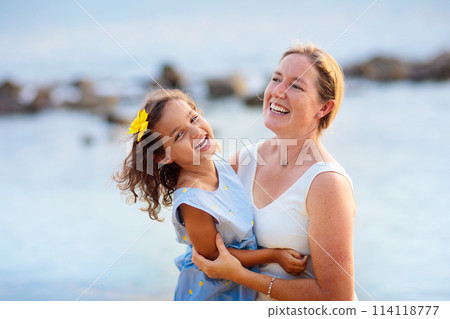 Mother and daughter on tropical beach. 114118777
