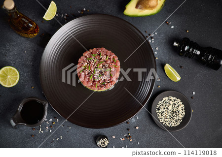 Tuna and avocado tartare on a dark ceramic plate Tuna and avocado tartare on a dark ceramic plate 114119018