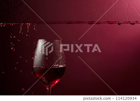 Red wine flows down into a glass. Red wine flows down into a glass. 114120934