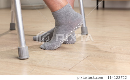 Elderly woman wear non slip grip socks for senior people who have trouble keeping their balance. Elderly woman wear non slip grip socks for senior people who have trouble keeping their balance. 114122722