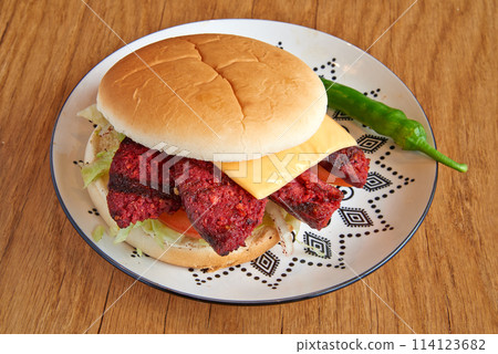Beef burger on decorated plate on wooden textured table 114123682