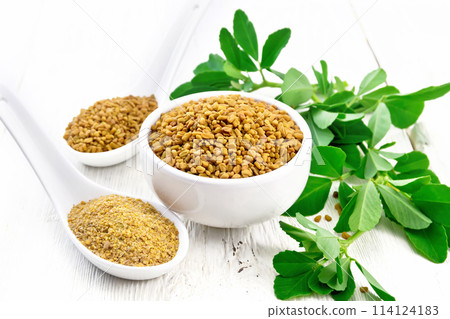 Fenugreek in bowl and two spoons with leaves on white board Fenugreek in bowl and two spoons with leaves on white board 114124183