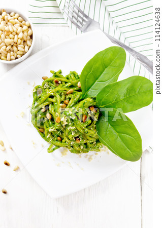Spaghetti with spinach and nuts in plate on board top Spaghetti with spinach and nuts in plate on board top 114124638