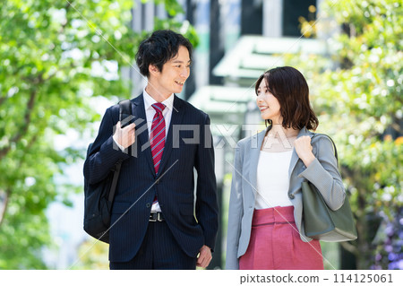 Business people walking through a green office district 114125061