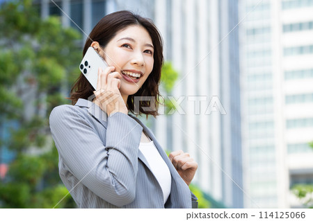 在商業區使用智慧型手機的年輕女性 114125066